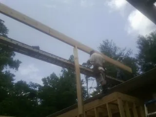 Carpenter setting a ridge beam over a new addition frame — Ice Dam Removal by Roofing Brothers in Moundsville