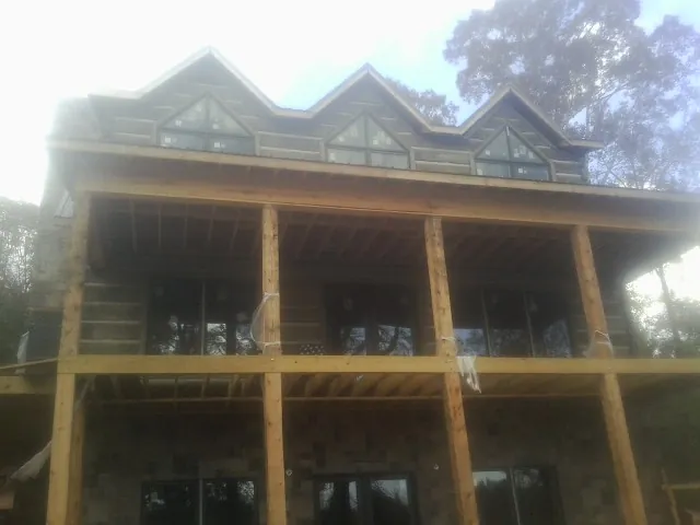 Dormers and porch framing on a large log home under construction — Roof Coating work by our crew in Moundsville