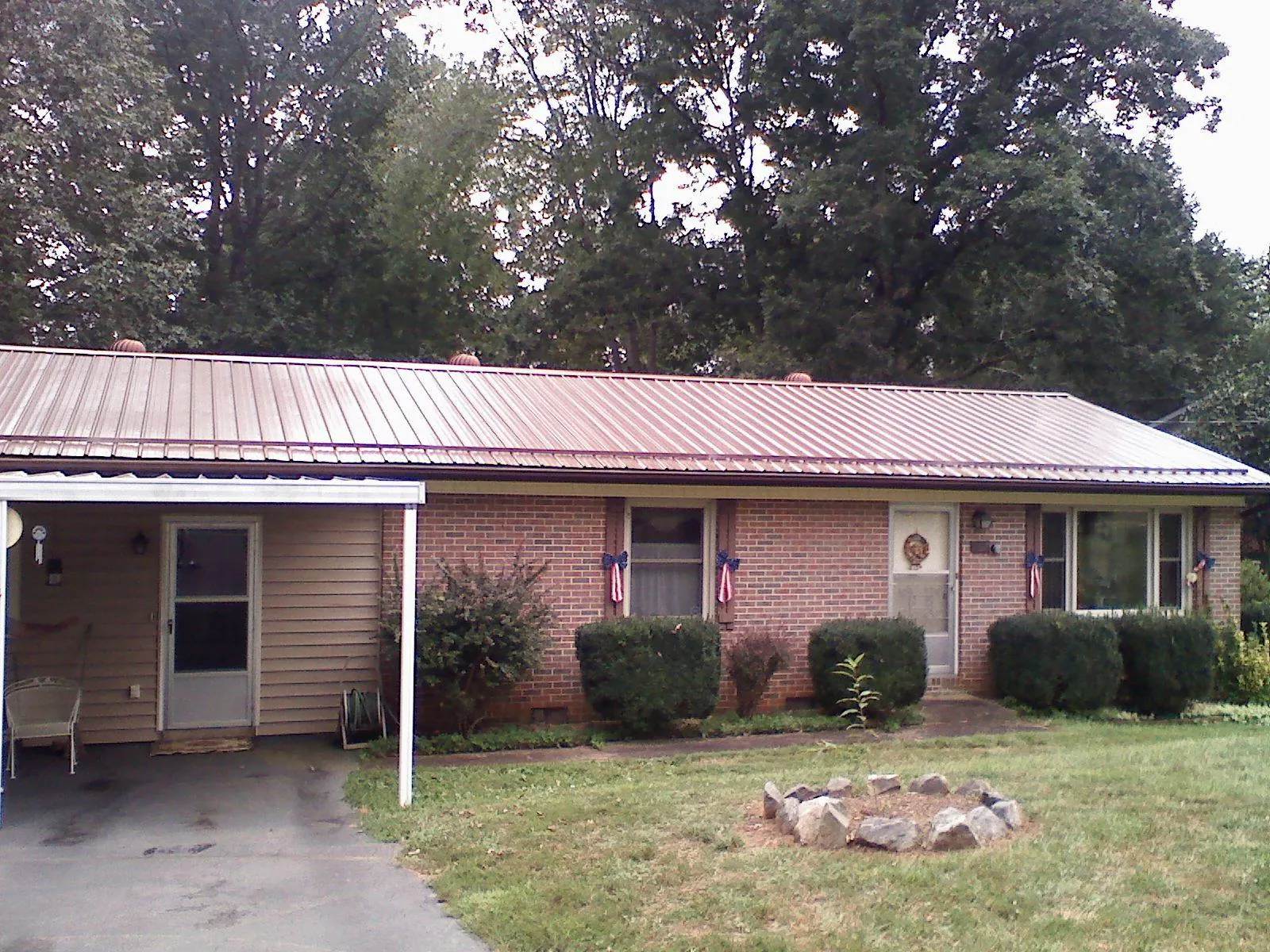 Bronze metal roof and carport on a brick ranch home — Roof Repair work by our crew in Moundsville