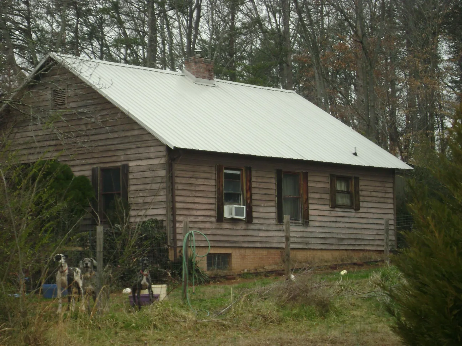 White metal roof on an old wood sided farmhouse, from a Metal Roof Installation job in Moundsville